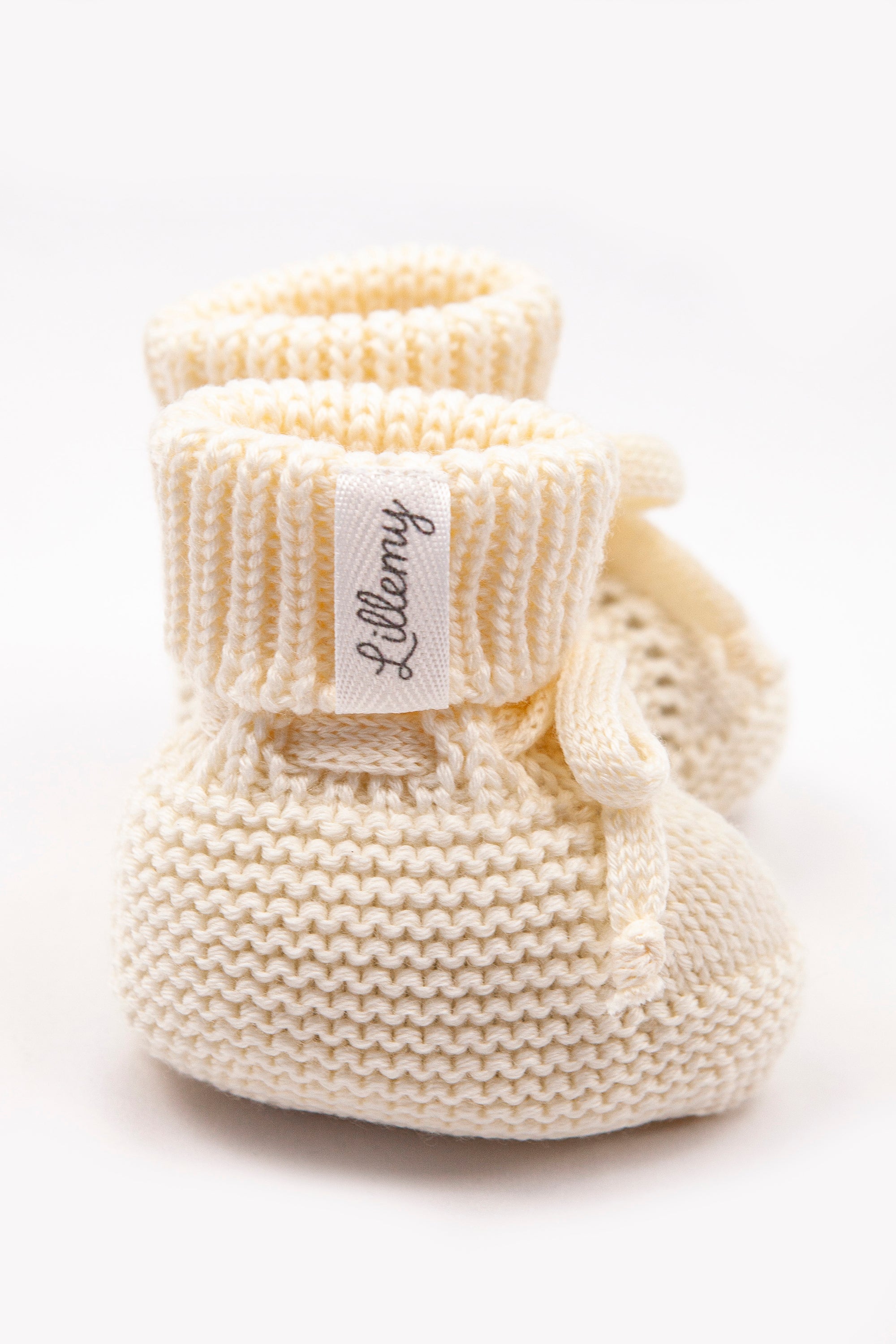 cream merino wool baby booties flat lay – newborn gift, shipped from London