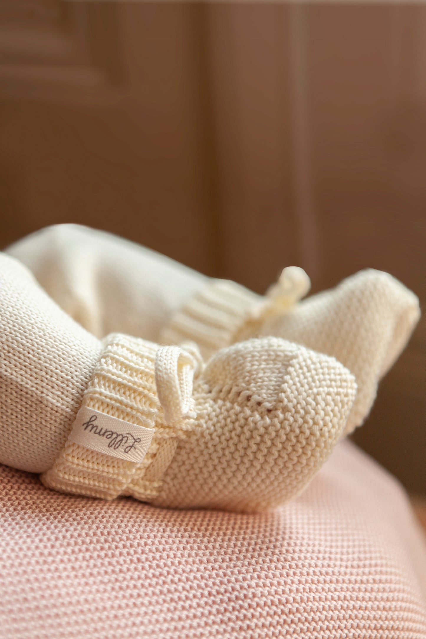 cream merino wool baby booties worn – snug fit with simple tie fastening